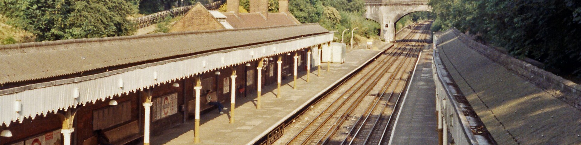 Chigwell station, 1984. View eastward, towards Fairlop, Hainault and Leytonstone (formerly to Ilford) on the Woodford - Hainault section of the London Underground Central Line, formerly the ex-GER Woodford - Fairlop - Ilford loop line. It was taken over from BR(ER) (ex-LNER, ex-GER) by the LPTB from 21/11/48: the station remains typical GER and the 'Tube' trains, from miles away at West Ruislip or Ealing Broadway, still seem out of place
