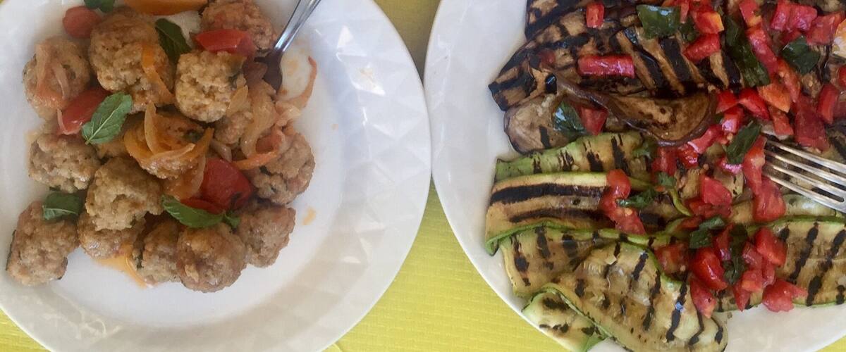 Three plates of food on a yellow tablecloth.