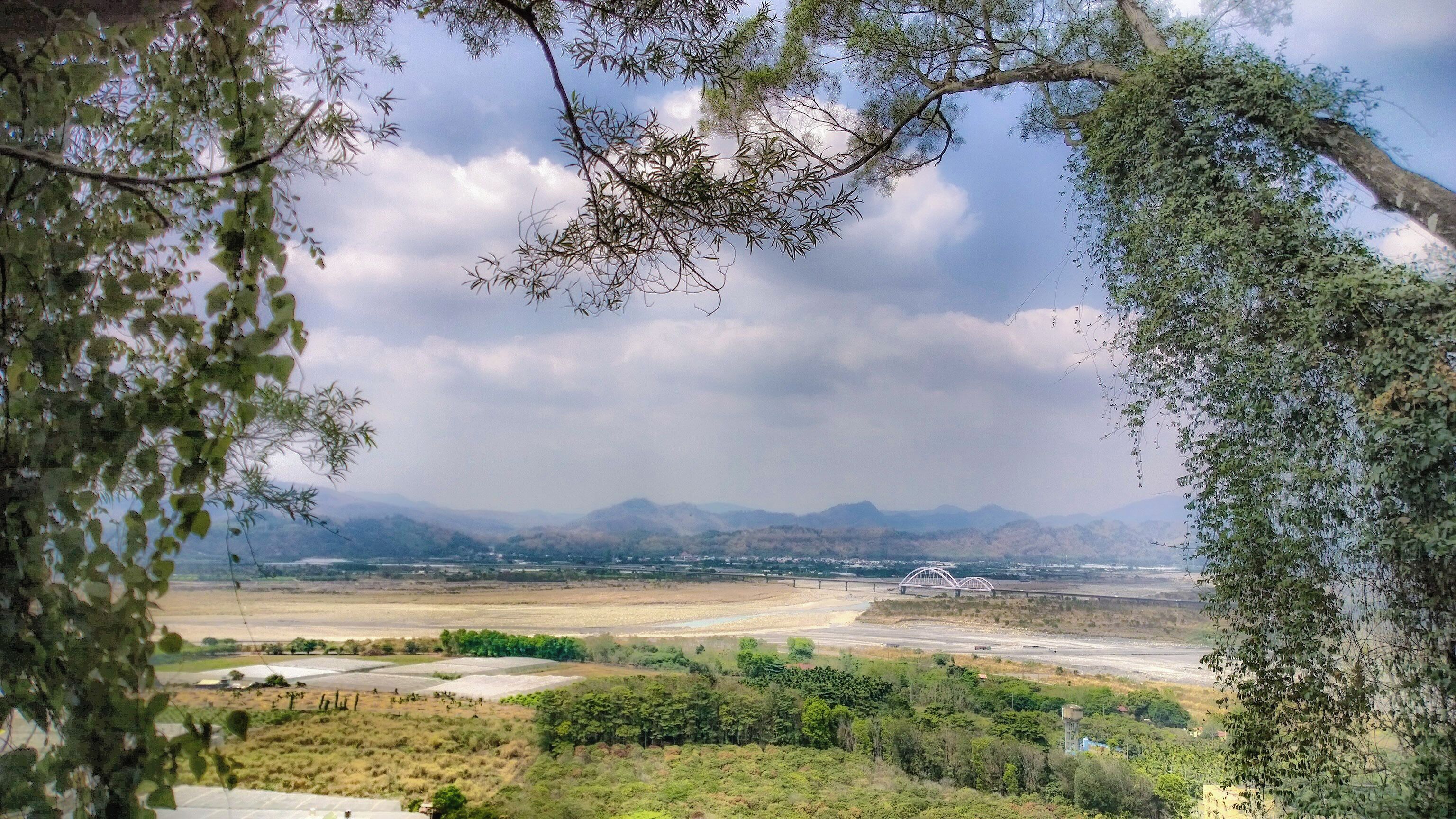 Laonong River passing through Xinwei Village, with the Yushan Range in the background. In the middle of the picture is Xinwei Bridge.