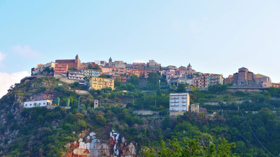 A hillside town with colorful buildings and a prominent church.