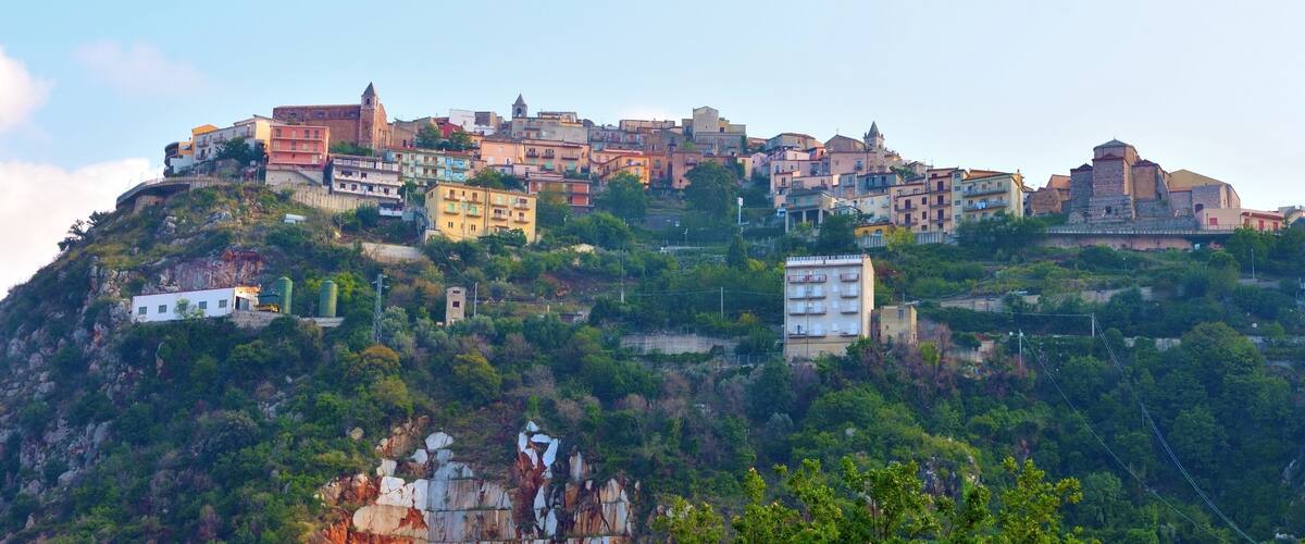 A hillside town with colorful buildings and a prominent church.