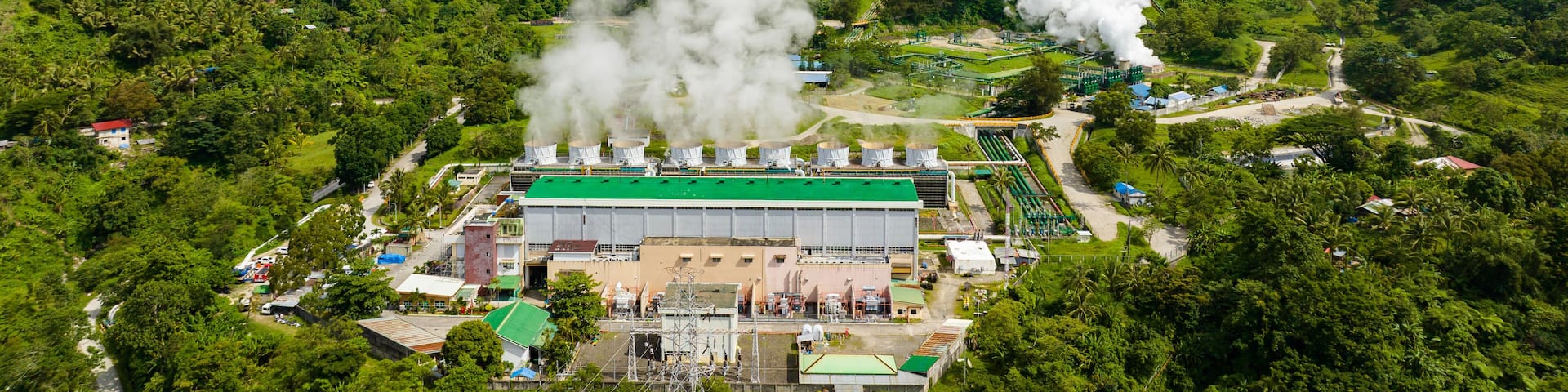 Aerial view of geotermal power plant in the mountains. Geothermal station with steam and pipes. Negros, Philippines.
