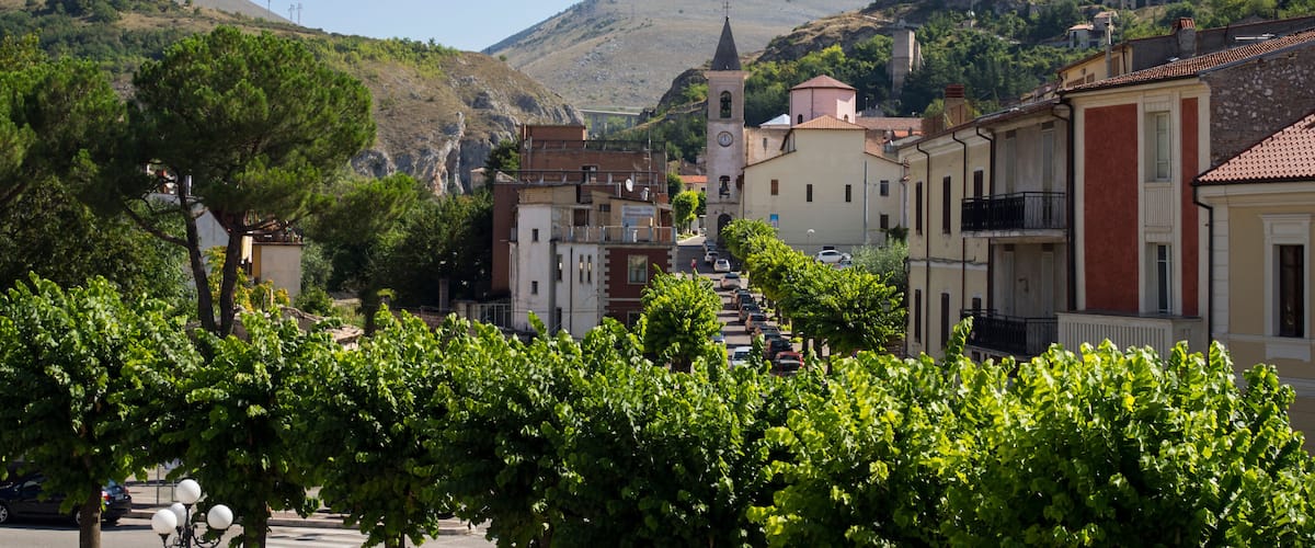 A town with a church, wind turbines, and a castle on a hill.