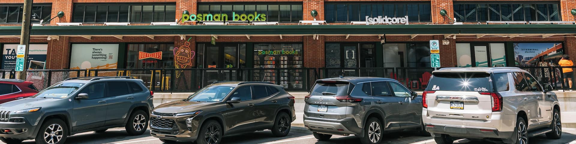 A building with a large sign reading 'THE TERMINAL' and storefronts for 'posman books' and 'solidcore.'