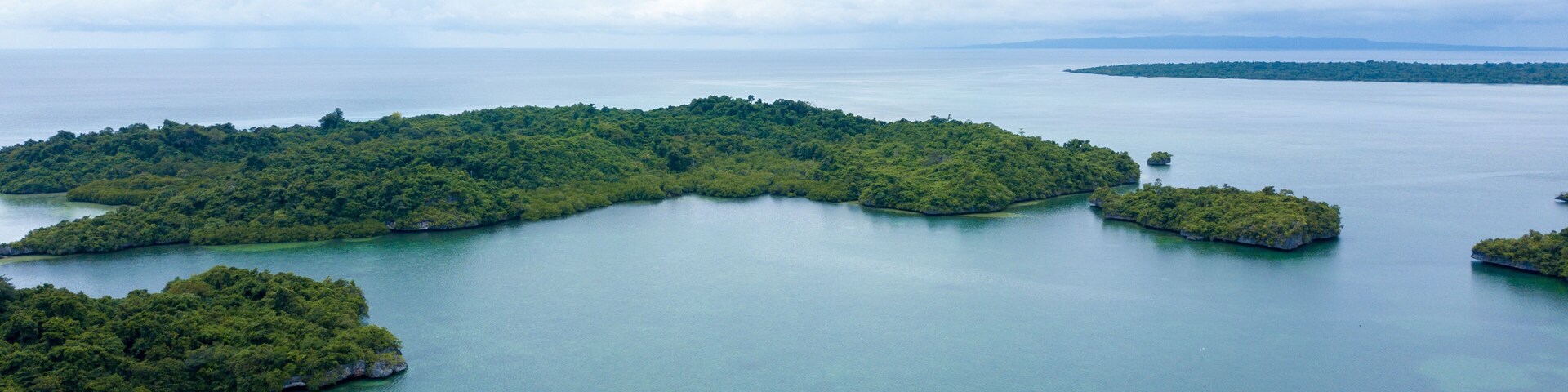 An aerial view of a lush, green island surrounded by calm blue waters.
