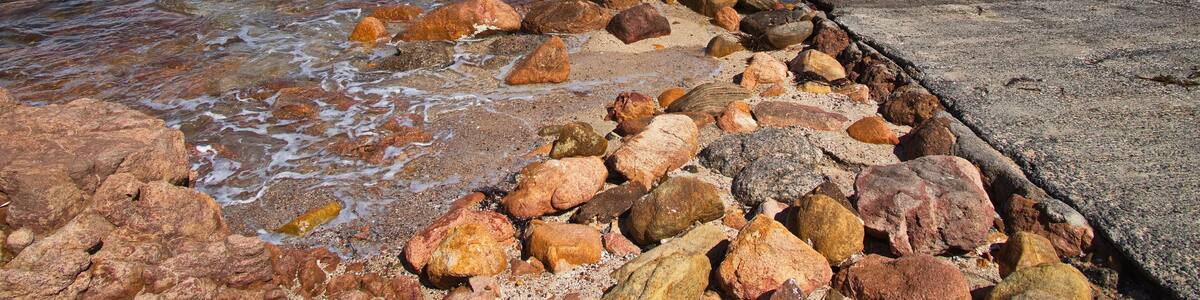 A rocky shoreline with a wooden pier extending into the water.