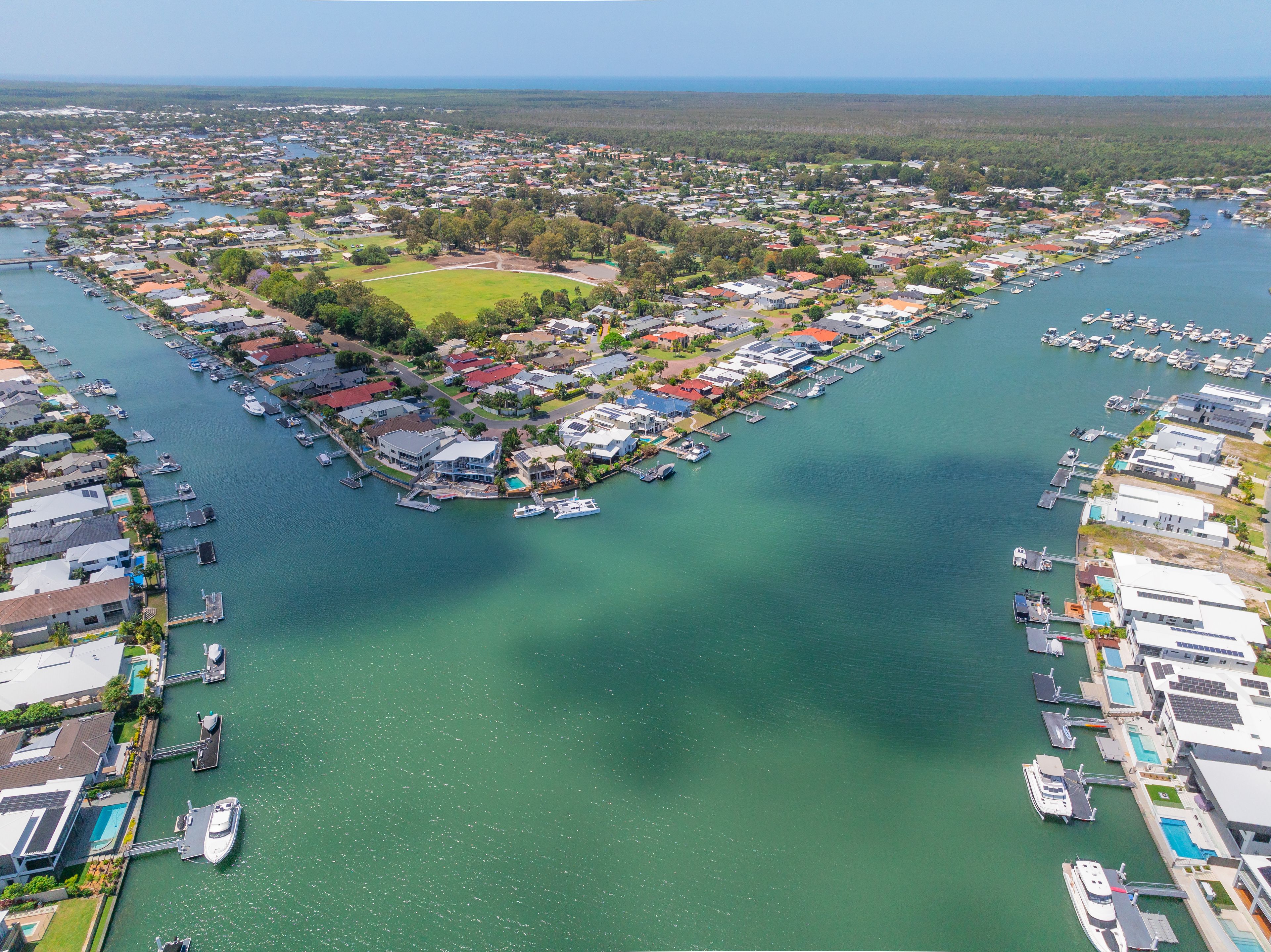 Aerial view of waterfront houses and jettys along wide coastal canals