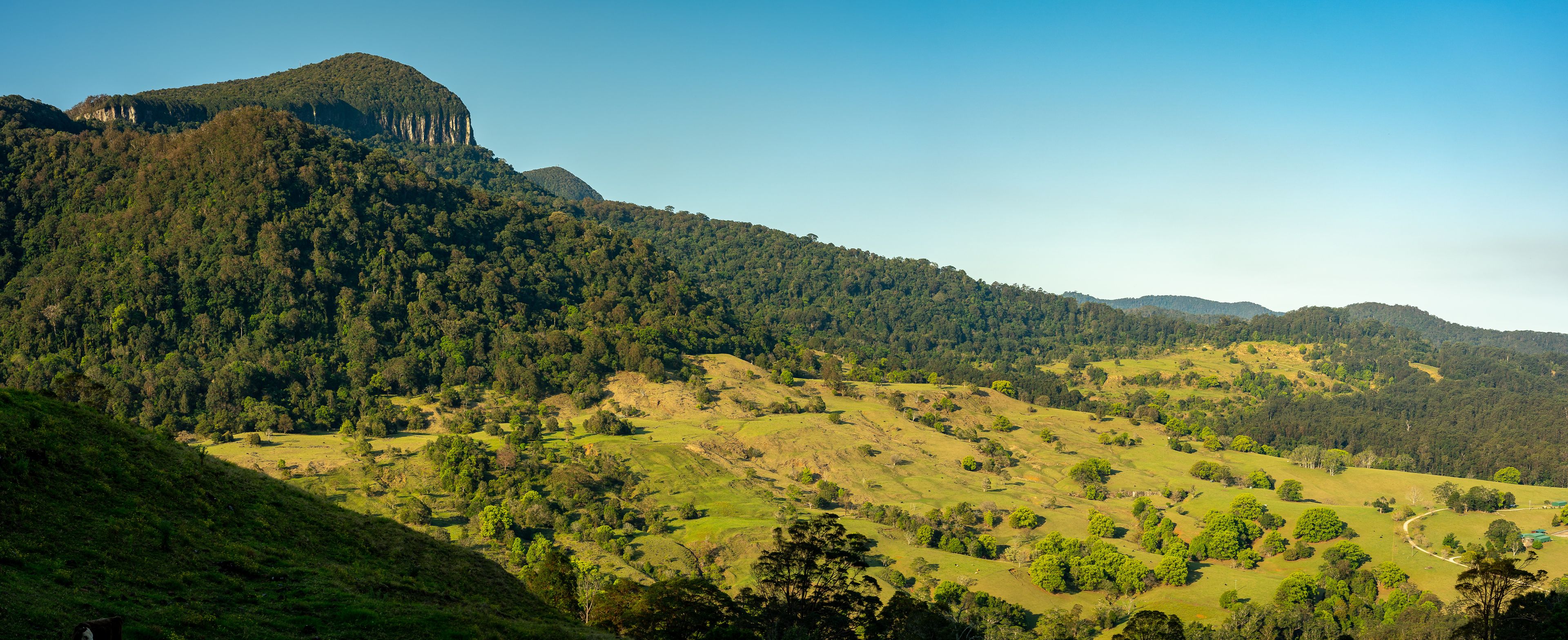 Paisagem montanhosa com florestas densas e colinas ondulantes.