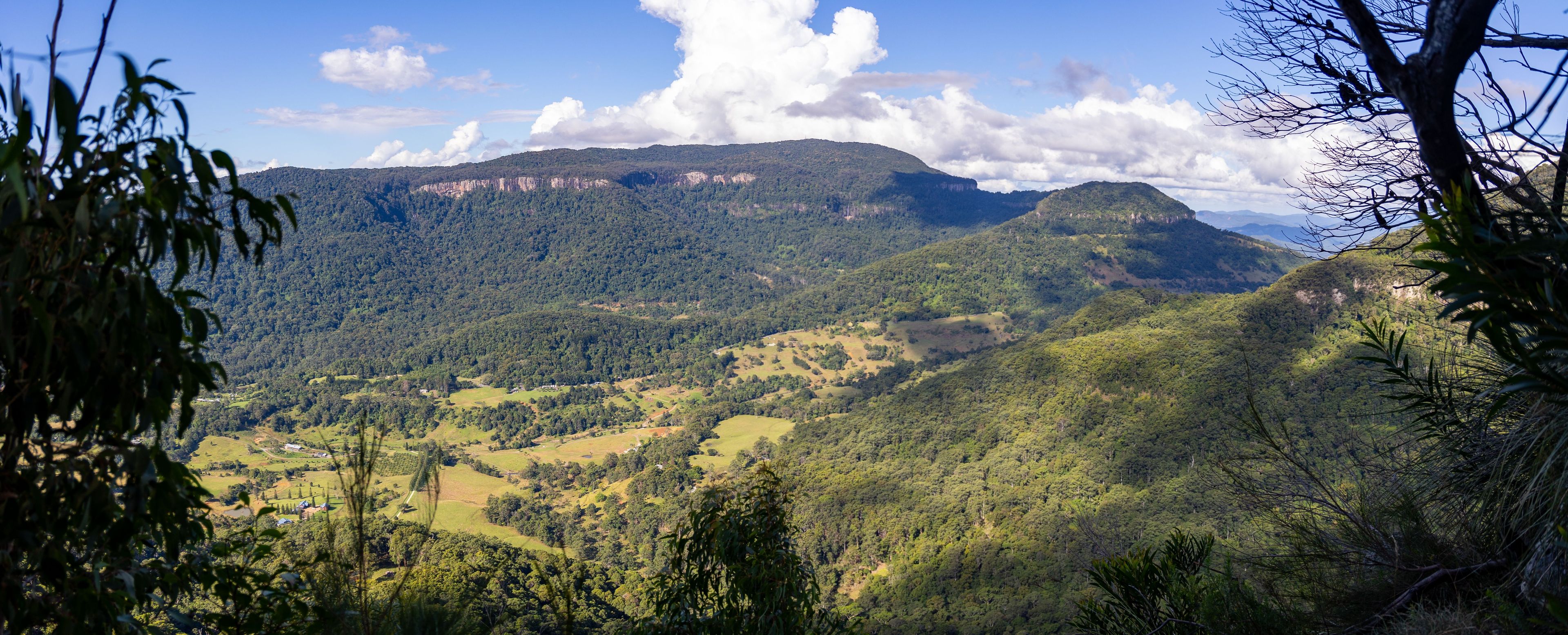 Paisagem montanhosa com florestas densas e céu limpo.