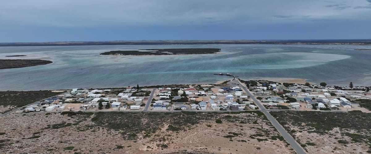 A coastal town with a marina and clear blue waters.