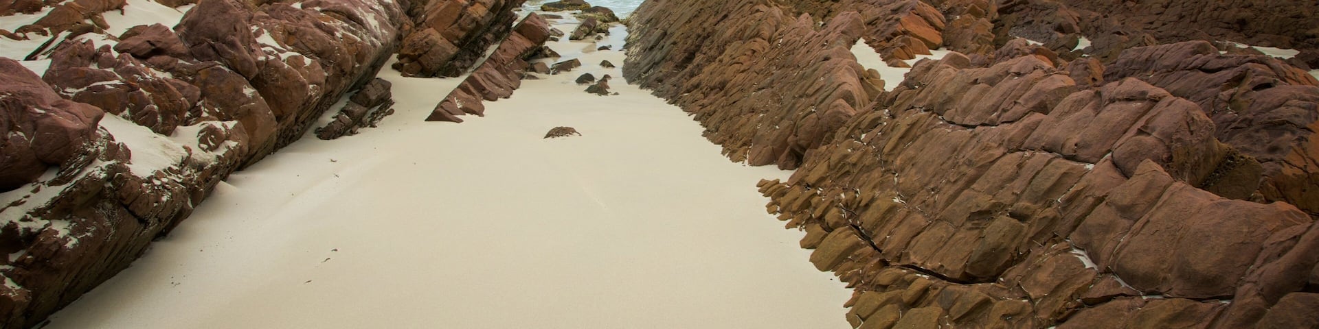 Stokes Bay showing rocky coastline, a beach and general coastal views