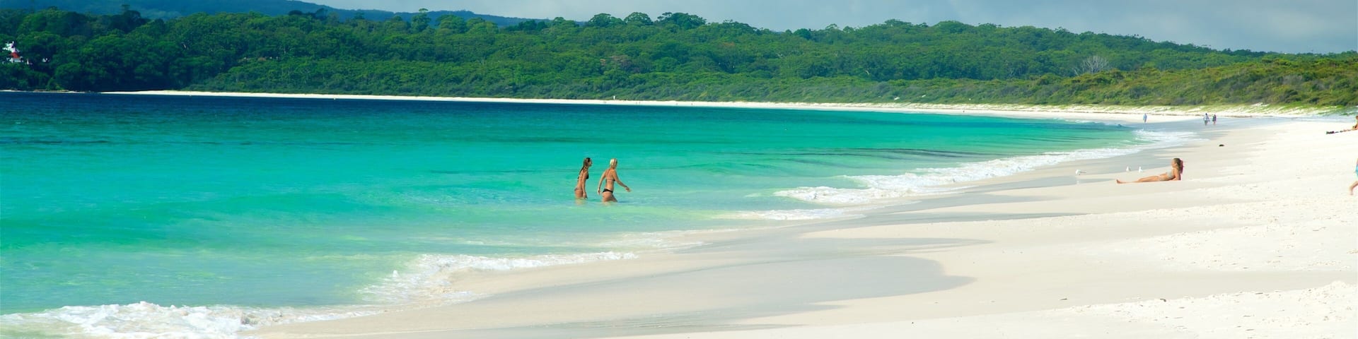 Huskisson which includes general coastal views and a sandy beach as well as a small group of people