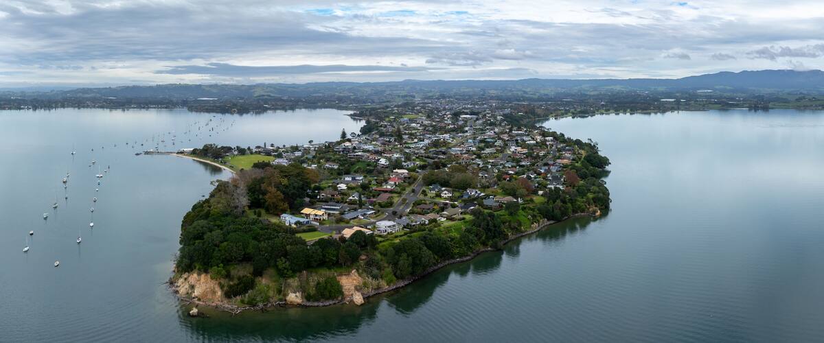 An aerial view of a small island with dense residential buildings surrounded by calm water.
