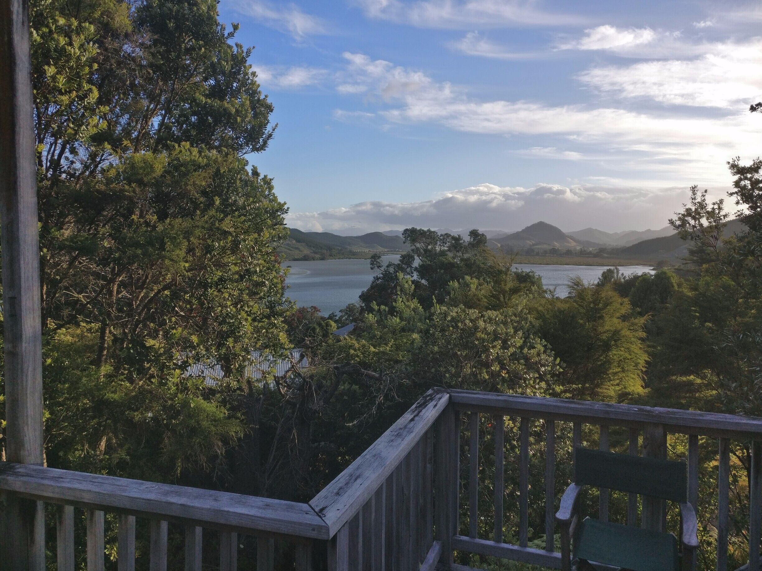 A wooden deck overlooking a lake with mountains in the background.