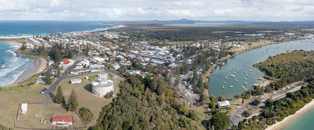A coastal town with a beach, marina, and dense residential area.