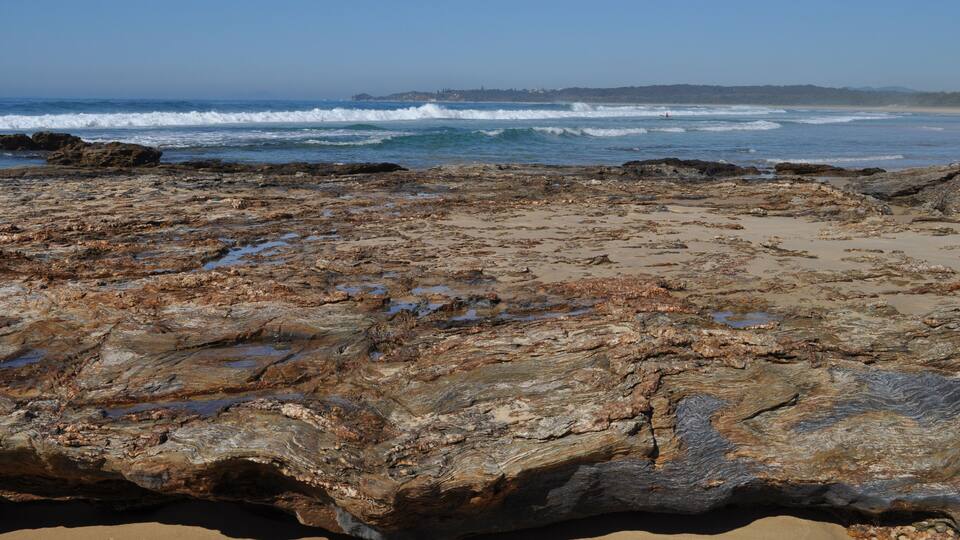 A rocky shoreline with waves crashing onto the beach.