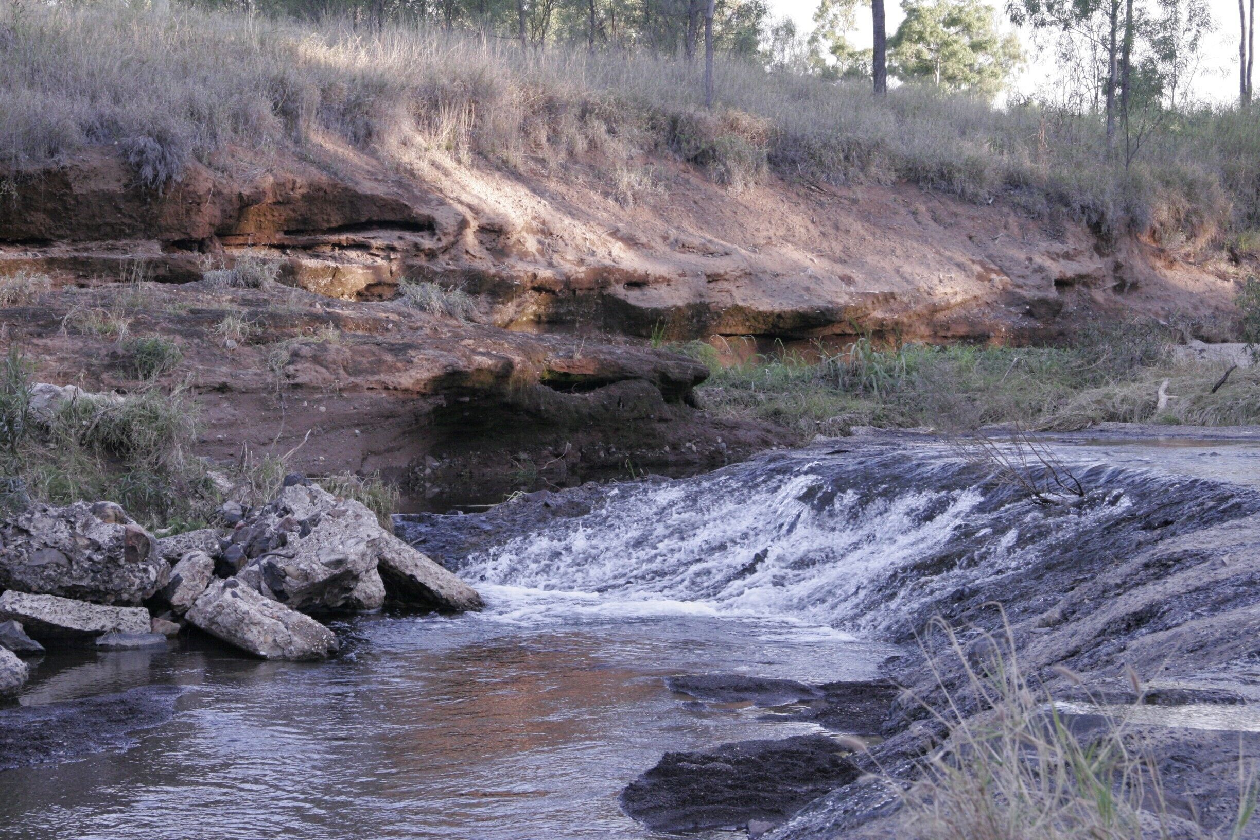 A rocky riverbed with water flowing over rocks.