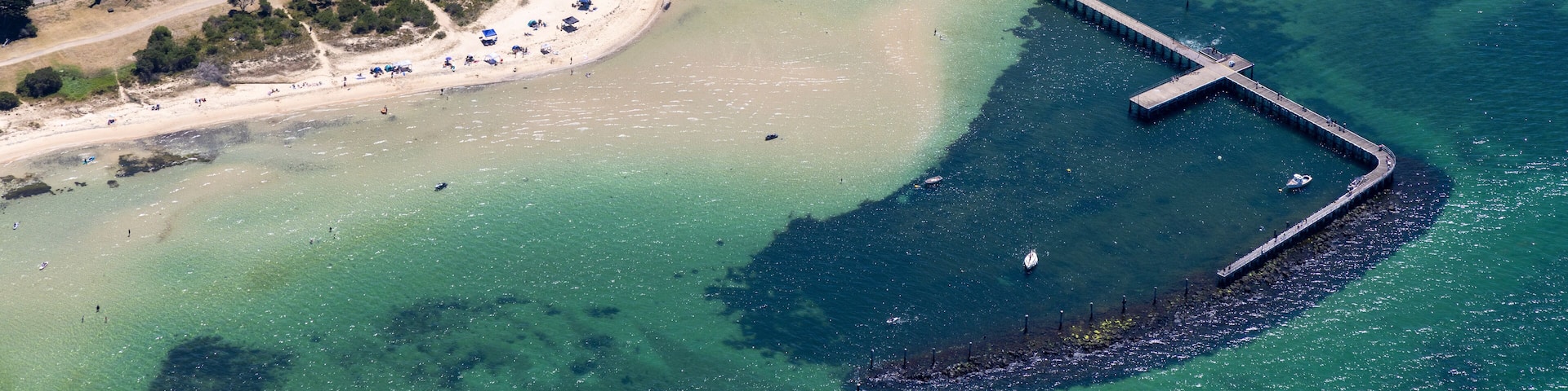Aerial view of milly beach with a picturesque pier and residential area, St Leonards, Victoria, Australia.