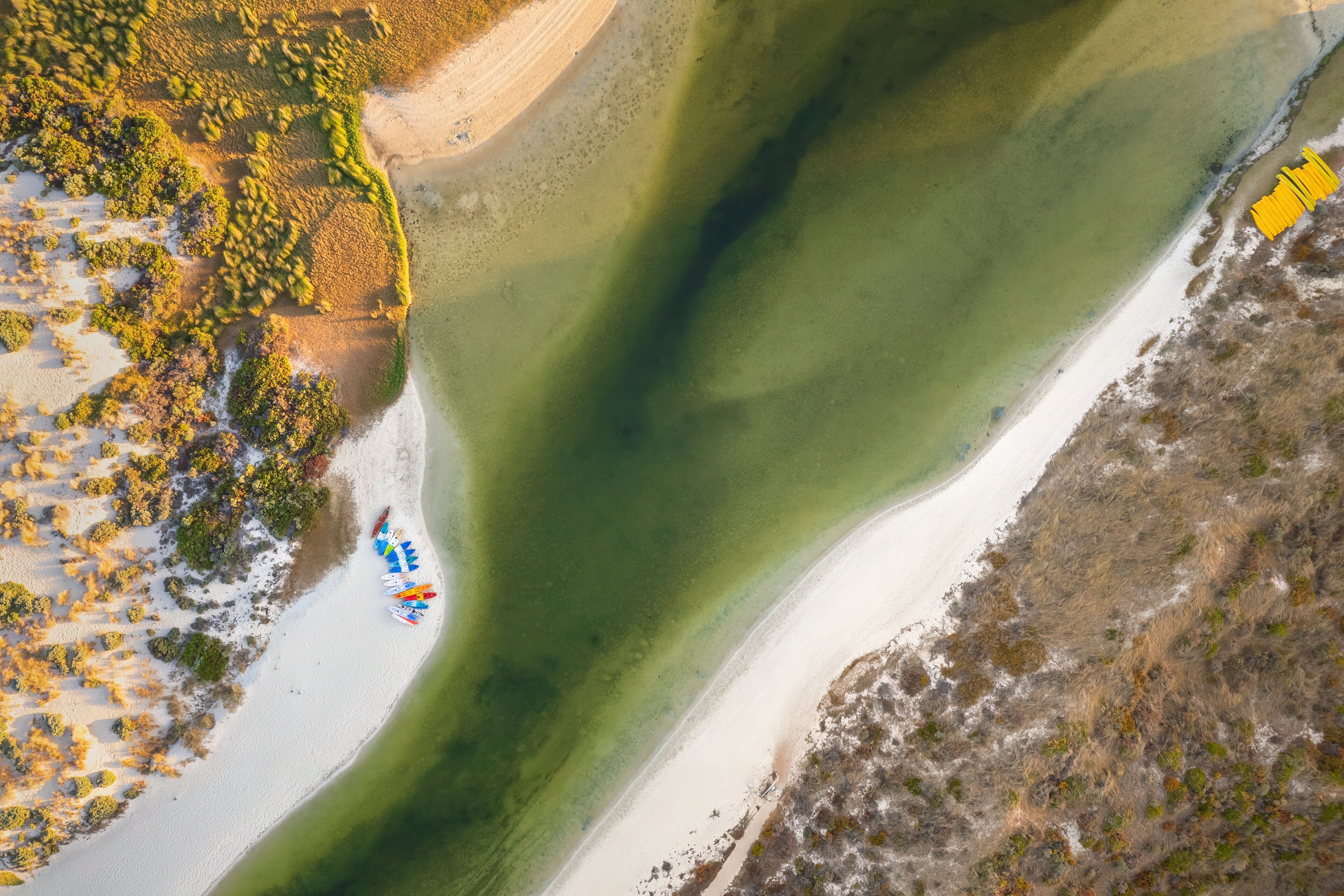 Aerial view of winding river flowing through beautiful landscape with serene beach and dunes, Margaret River Mouth, Burnside, Western Australia, Australia.