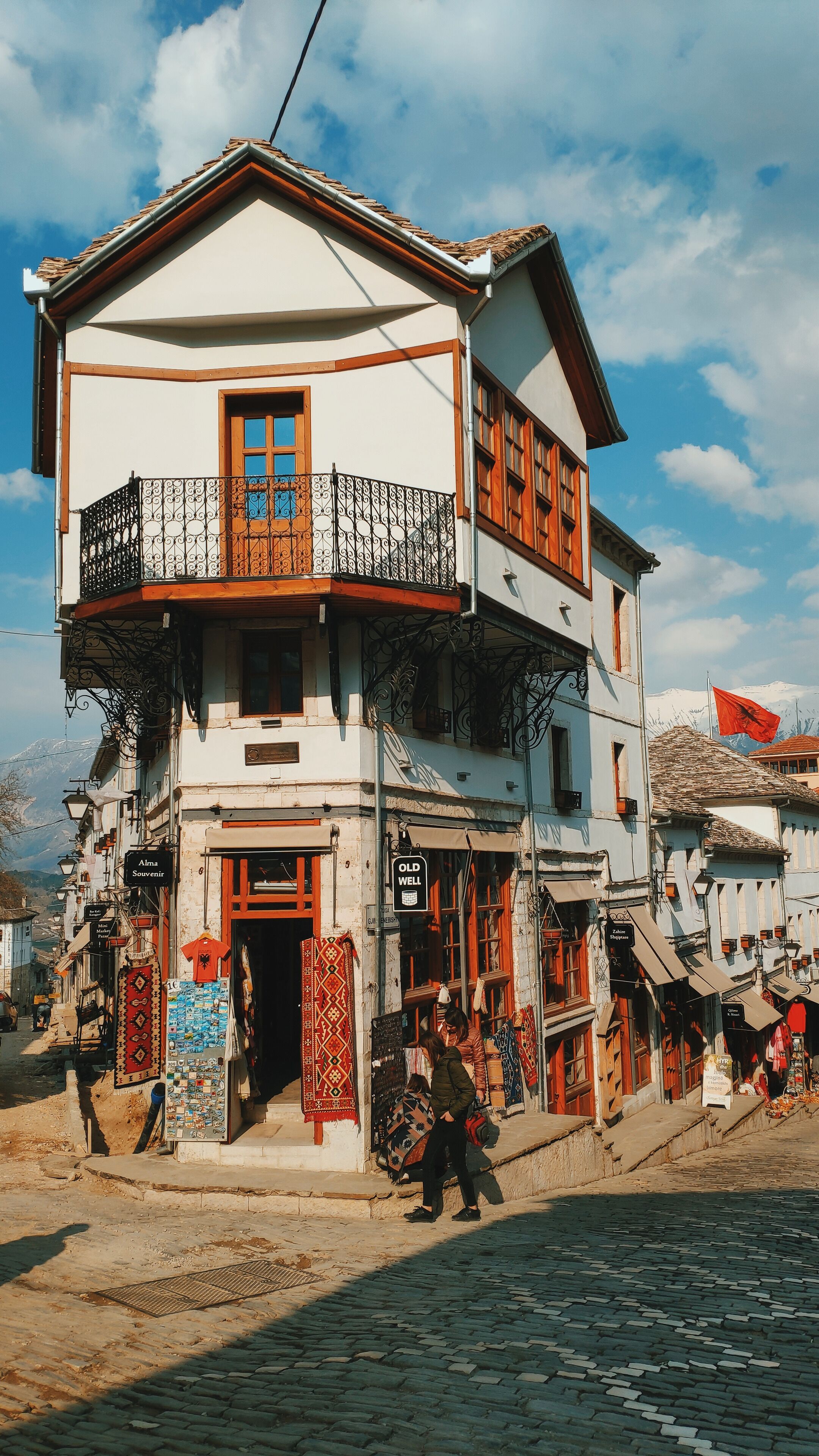 The old town of Gjirokastër, Albania: A main crossroad and this typical house which holds an old well on the ground floor (once a bar café today a souvenir shop).