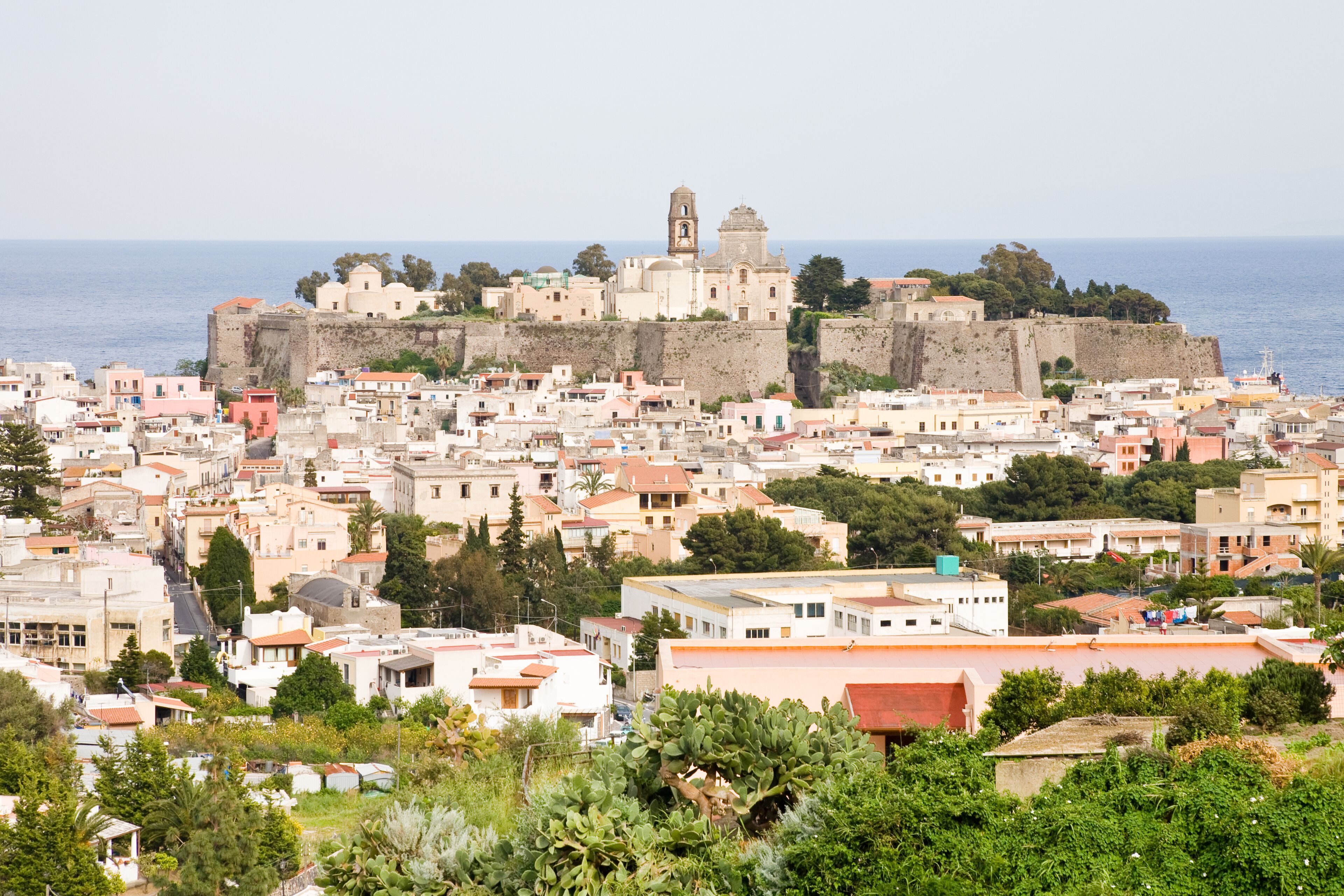 A coastal town with historic fortifications, a prominent church, and dense residential buildings.