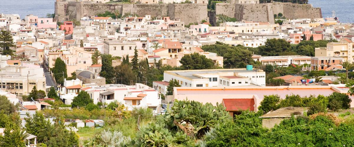 A coastal town with historic fortifications, a prominent church, and dense residential buildings.