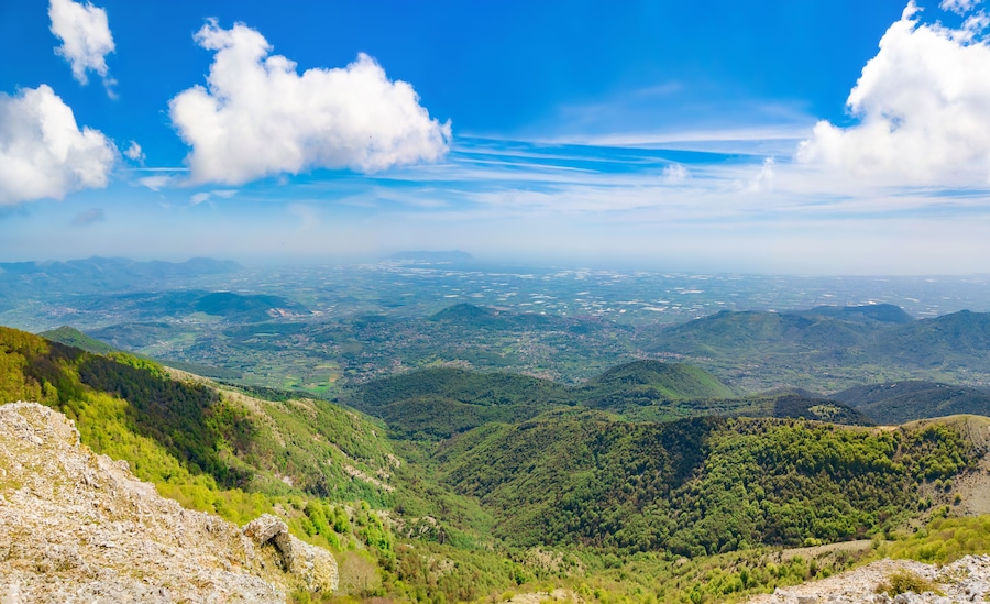 Un paisaje montañoso con un valle y una ciudad distante.