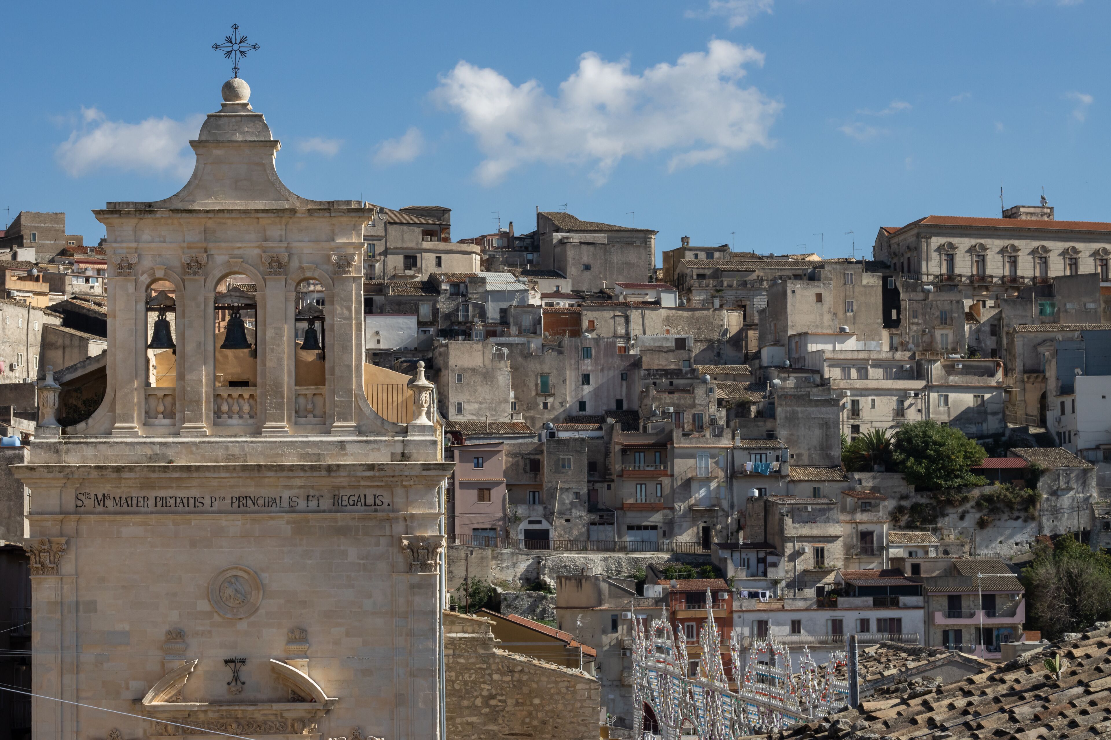 A historic church with a bell tower and a densely packed urban backdrop.