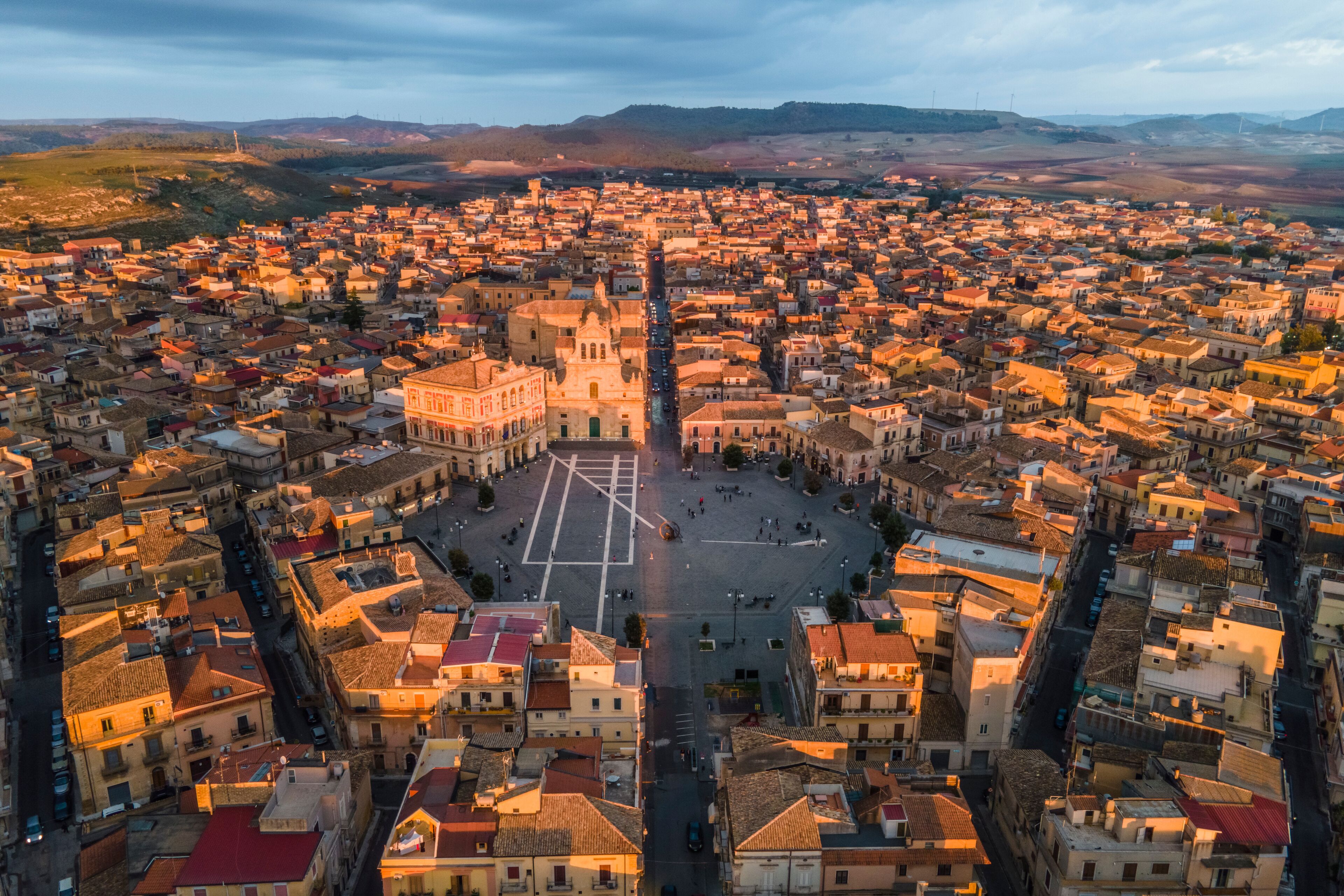 A panoramic view of a densely packed town with a prominent square and a large church in the center.