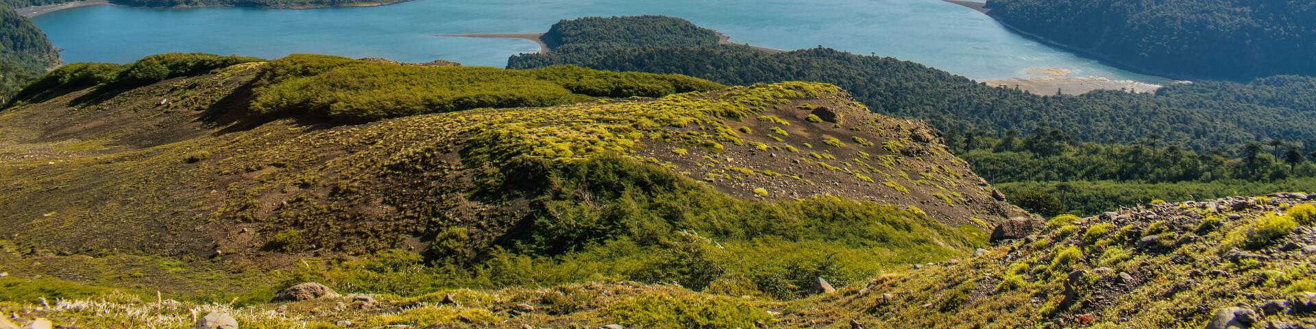 A mountain with a lake at its base and a forested valley.