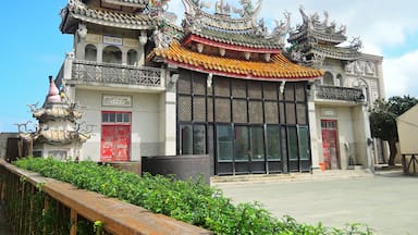 Un edificio tradicional chino con arquitectura ornamentada, que incluye esculturas de dragones y tejados coloridos.