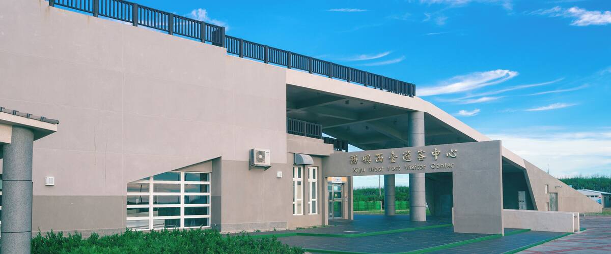 A modern building with a sign reading "Xiyu West Fort Visitor Center".