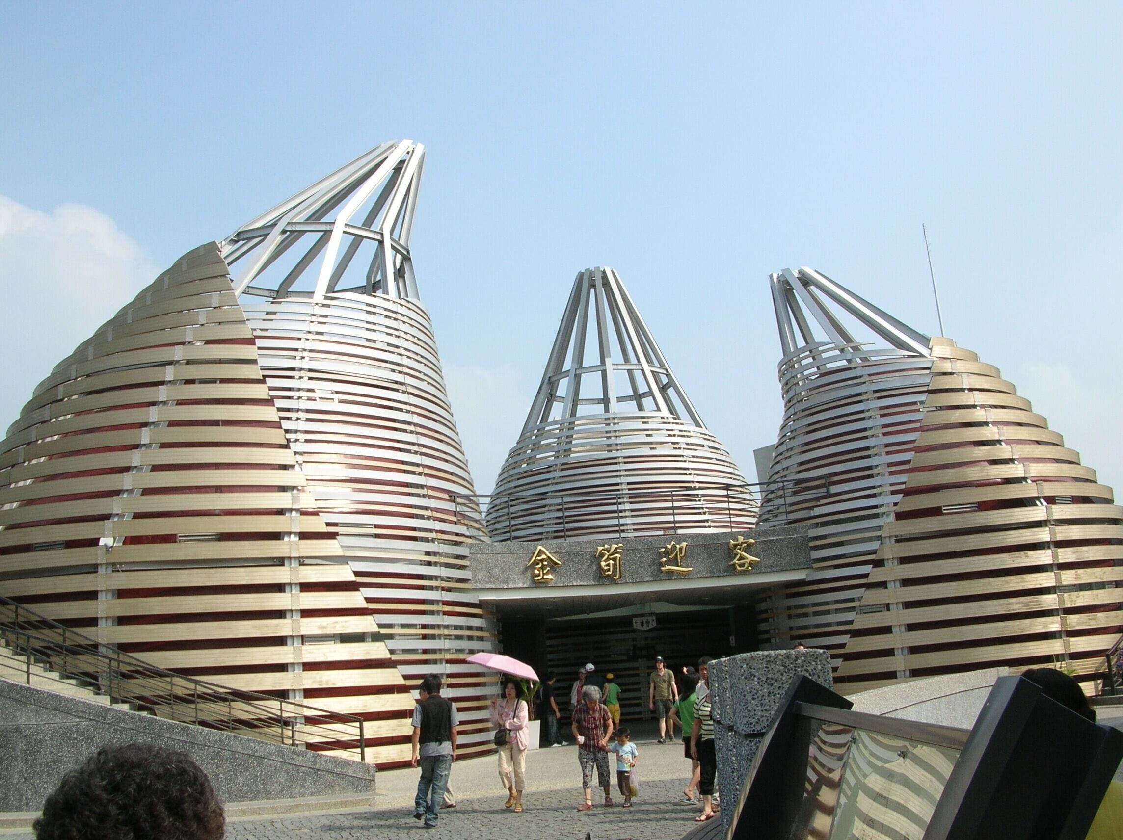 A modern architectural structure with three large, cylindrical buildings with slatted roofs.