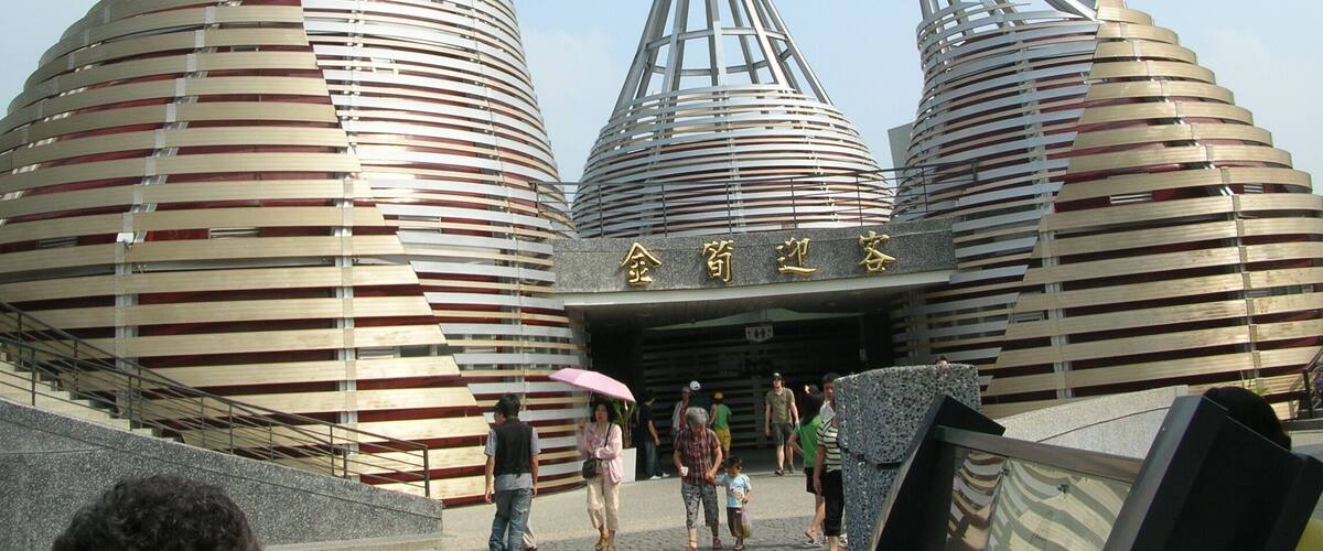 A modern architectural structure with three large, cylindrical buildings with slatted roofs.