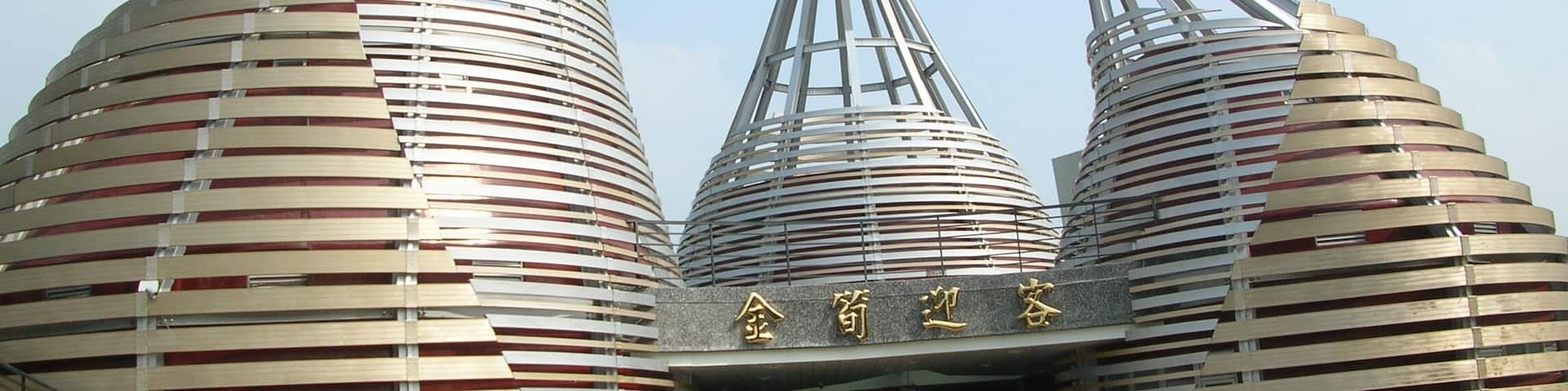 A modern architectural structure with three large, cylindrical buildings with slatted roofs.