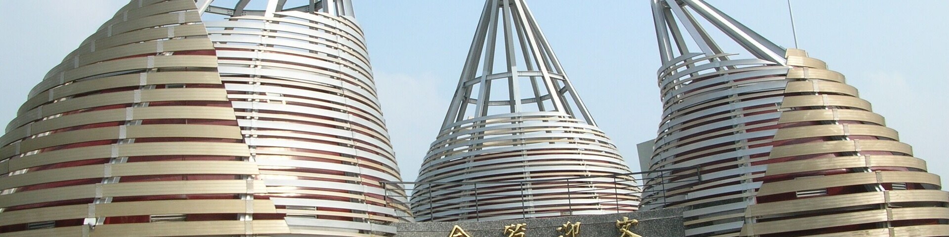 Una estructura arquitectónica moderna con tres edificios cilíndricos grandes y techos con listones.