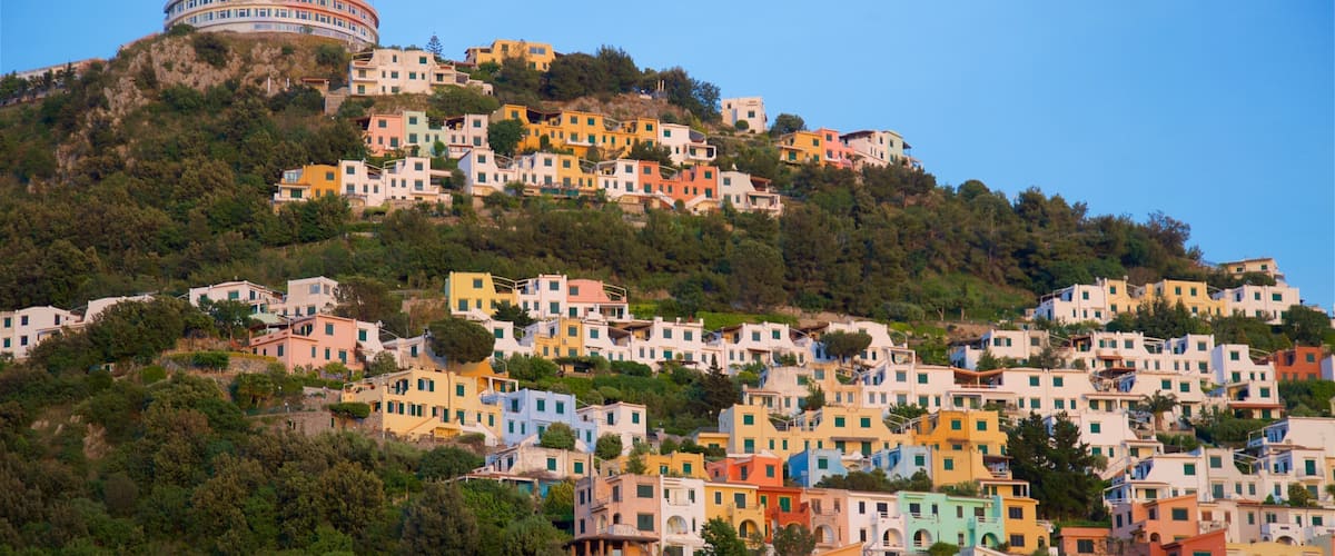 A hillside village with colorful buildings and a round tower.