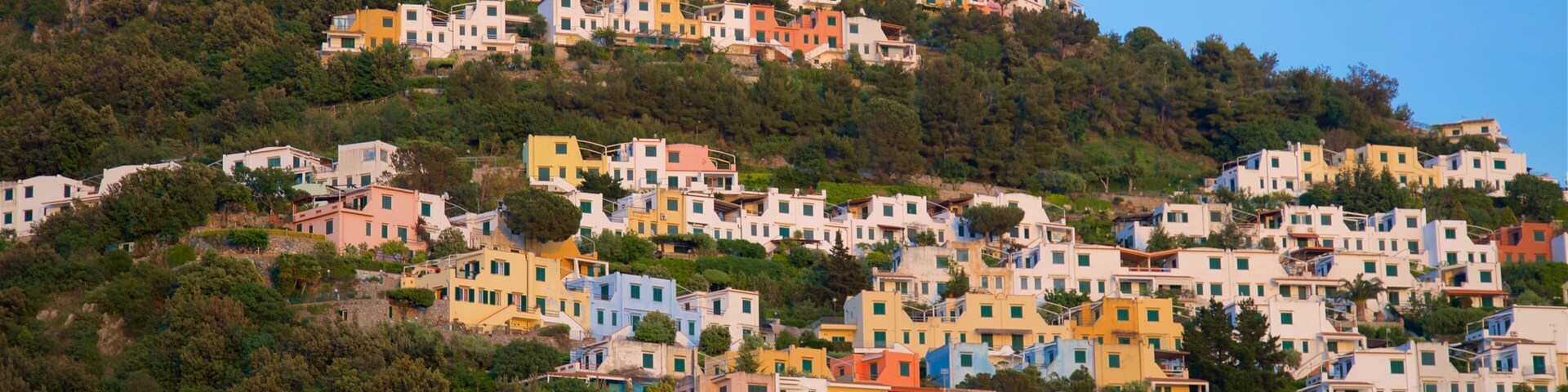 A hillside village with colorful buildings and a round tower.
