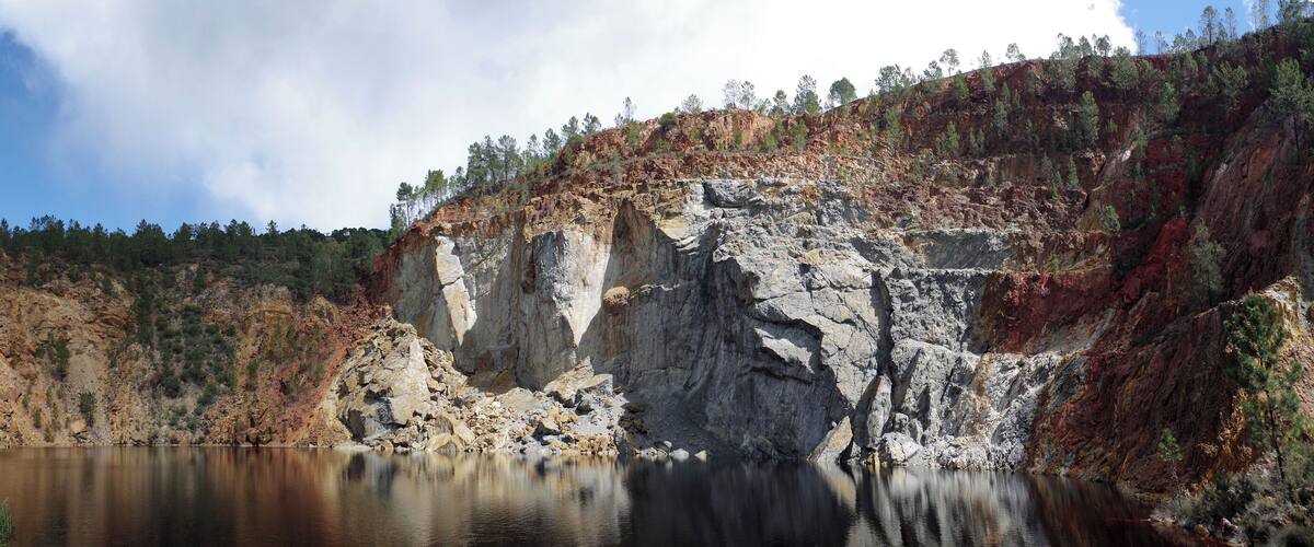 A lake surrounded by rocky cliffs and sparse trees.