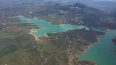 Paisaje montañoso con varios lagos turquesa y carreteras serpenteantes.
