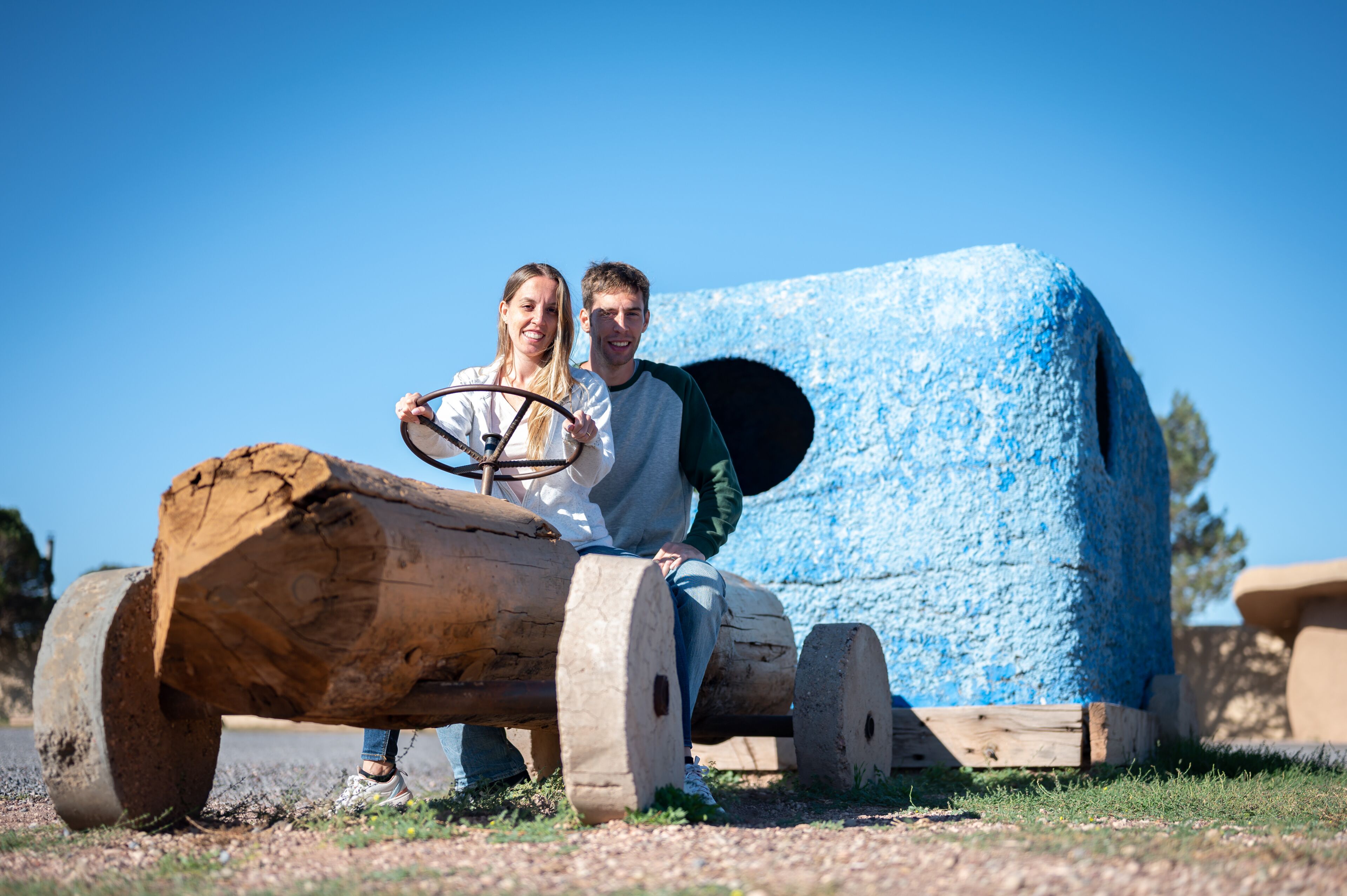 Young couple riding in the flintstones flintmobile