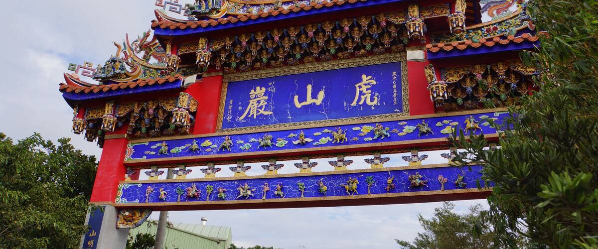 A traditional Chinese gate with intricate dragon sculptures and colorful decorations.
