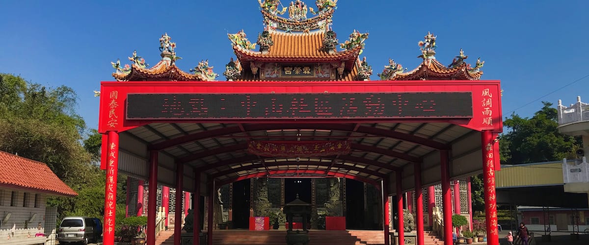 A traditional Chinese gate with ornate decorations and a digital display board.
