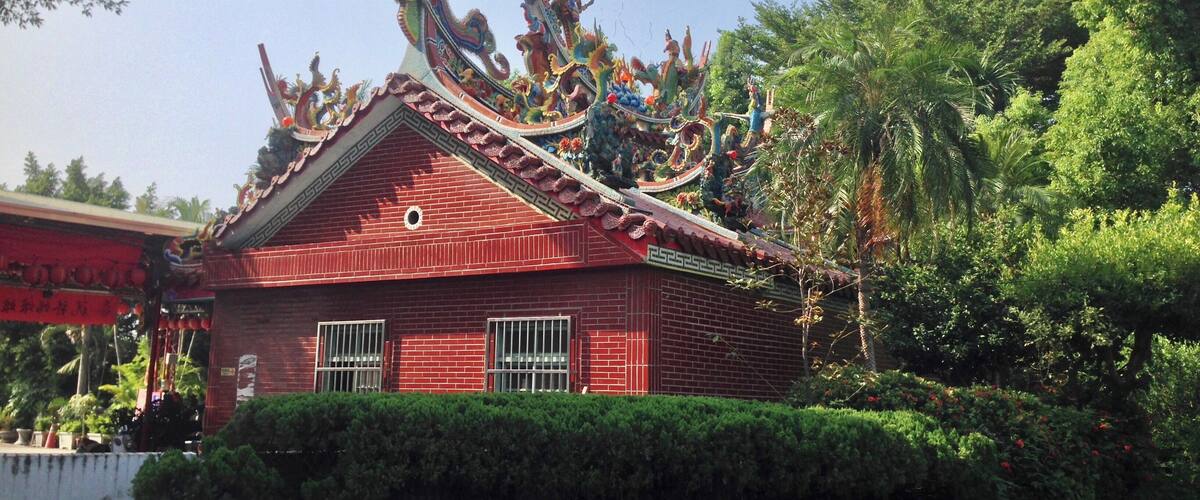 A traditional red building with ornate dragon decorations on the roof.