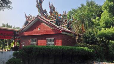 Un edificio rojo tradicional con elaboradas decoraciones de dragones en el tejado.