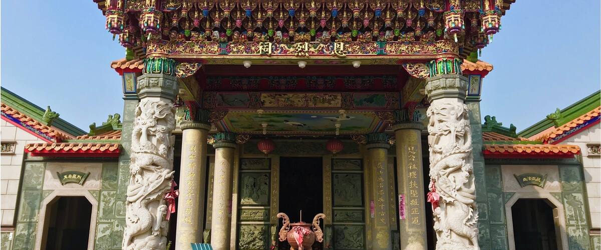 A traditional Chinese temple with ornate architecture, including a colorful roof and statues.