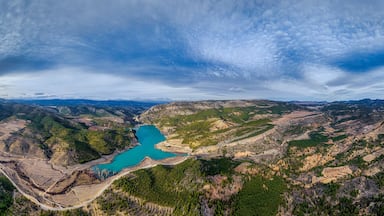 A mountainous landscape with a turquoise lake surrounded by forested areas and terraced fields.