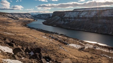 A river winding through a canyon with rocky terrain and sparse vegetation.