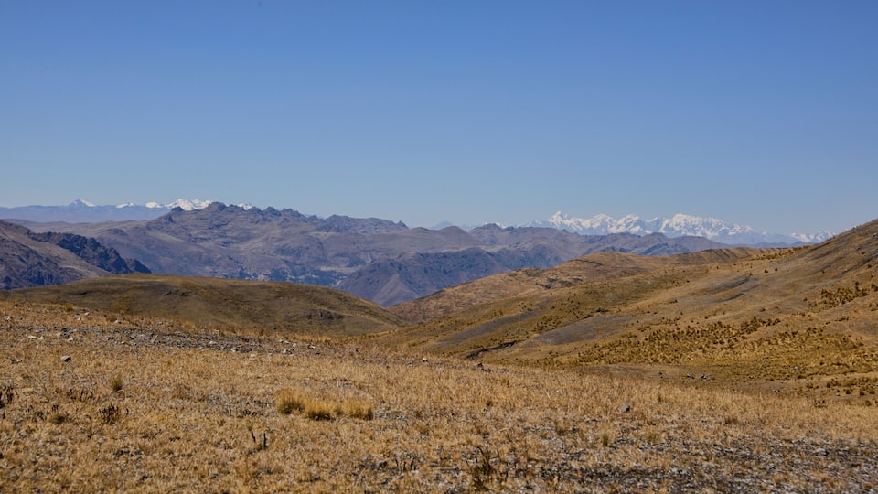 A mountainous landscape with dry grass and rocky terrain.