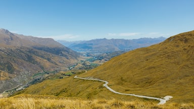 Uma estrada sinuosa serpenteando por um vale, rodeado por montanhas.